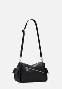 Sac bandoulière en cuir noir avec une finition texturée, une forme angulaire, une bandoulière réglable et une poche zippée à l'avant ; rabats latéraux pour un détail supplémentaire.