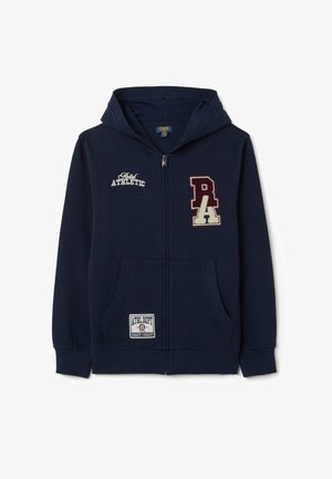 Hoodie in Marineblau mit einem Frontreißverschluss, zwei Seitentaschen und gestickten Aufnähern mit Text. Weicher Stoff mit gerippten Bündchen und Saum.