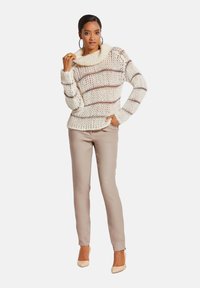Chunky crème gebreid sweater met bruine strepen, kraag en geribde manchet, gecombineerd met beige op maat gemaakte broek en naakte hoge hakken.