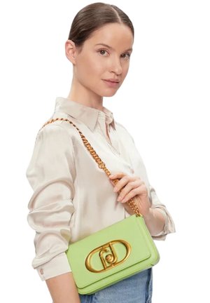 Borsa a tracolla in pelle verde chiaro con una chiusura ovale dorata, dotata di una tracolla a catena. Texture liscia e forma rettangolare, portata sotto il braccio.