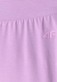 Tissu lilas avec détail de couture froncée et logo « 4F » en relief dans la partie supérieure droite du textile.