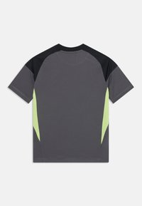 T-shirt gris à manches courtes avec des accents noirs et vert néon sur les épaules et les côtés. Texture lisse, design décontracté sans logos visibles.