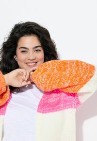 Sweter dziergany z oversize'owymi rękawami; w jaskrawych kolorach pomarańczowym, różowym i białym; miękka tekstura; szerokie mankiety; prążkowany wzór.