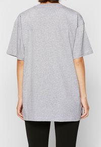 Grå oversized kortärmad t-shirt gjord av mjuk bomullsblandning med rund hals och rak skärning, med en ren, minimalistisk design.