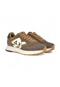 Braune Sneakers aus Wildleder und synthetischen Materialien. Sie verfügen über ein cremefarbenes Logo, beigefarbene Schnürsenkel und eine weiße Zwischensohle mit einer strukturierten Gummilaufsohle.