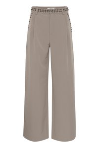 Pantalons larges beiges à taille haute, avec une ceinture cloutée et des poches latérales, confectionnés dans un tissu lisse et léger.