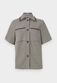 Chemise à manches courtes boutonnée avec motif pied-de-poule noir et blanc, garniture contrastante sur le col et les poches poitrine.