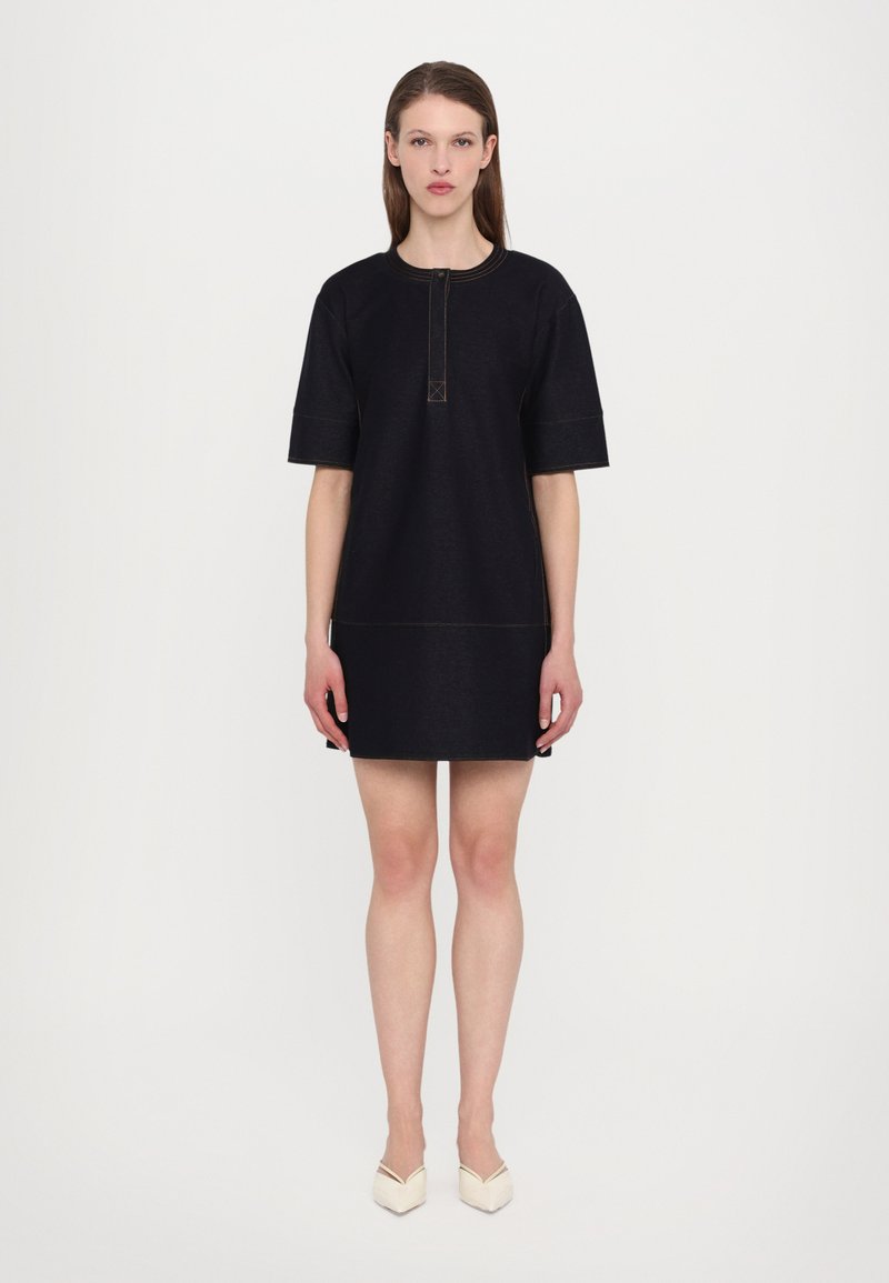 Robe en denim noir à manches courtes, décolleté rond et détail de bouton à l'avant. Elle présente des surpiqûres contrastantes et une silhouette droite.