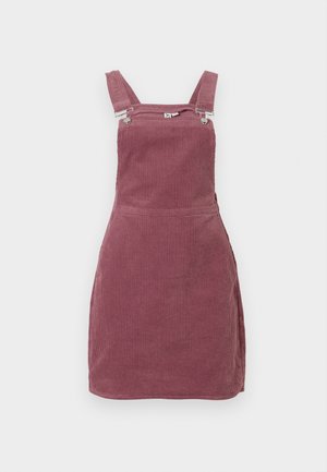 Robe en velours côtelé rose poussiéreux, avec des bretelles réglables et des éléments en métal. Tissu texturé avec des côtes verticales et une silhouette ajustée.