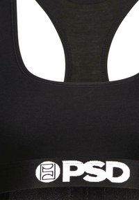 Crna sportska grudnjak s dizajnom na leđa, mekana tkanina i široka elastična traka s bijelim "PSD" logom. Glatka tekstura tijekom cijele površine.