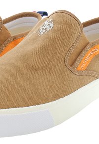 Hnědá nazouvací bota vyrobená z látky, se š orange akcentem, bílou gumovou podrážkou a malým logem na boku.