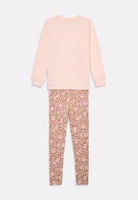 Világos rózsaszín, hosszú ujjú felső, kerek nyakkivágással, melyet nadrágra illeszkedő leggings-szel kombináltak, amelyen rózsaszín és zöld virágminták találhatók mályva színű háttéren.