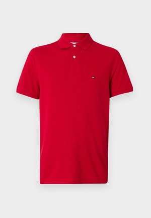 Rode katoenen polo shirt met een klassieke kraag, drie knopen sluiting, korte mouwen en een klein logo op de linkerborst.
