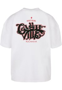Fehér pamut póló rövid ujjal, az hátsó részen nagy fekete és piros stilizált grafika látható, amelyen a "CASTLE VILLE" és a "ROC-A-WEAR" felirat szerepel.