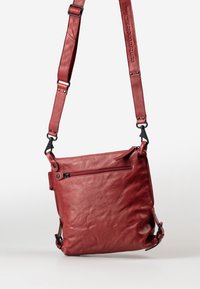 Rote Leder-Crossbody-Tasche mit verstellbarem Tragegurt, Reißverschluss, frontaler Reißverschlusstasche und weicher, texturiertem Finish. Akzente bestehen aus Metallbeschlägen.