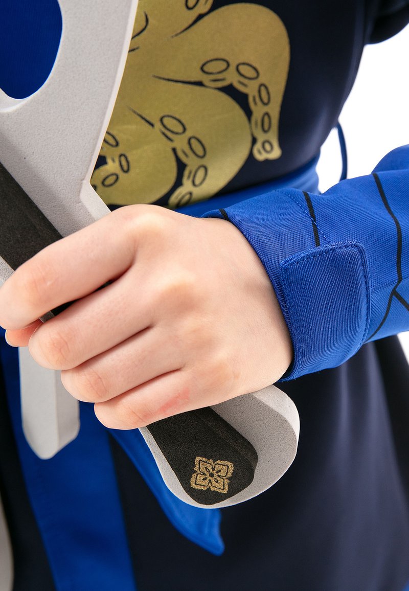 Blue long-sleeve garment with a black and gold octopus design. Hand gripping a gray foam sword with a textured black handle and gold accent.