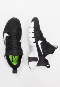 Sort og hvide Nike træningssko med mesh-overdel og karakteristiske segmenterede hvide såler, vist fra top- og sidevinkler.