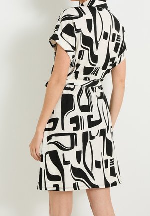 Sukienka z krótkim rękawem o czarno-białym abstrakcyjnym wzorze, wykonana z teksturowanej tkaniny, z paskiem do wiązania w talii.