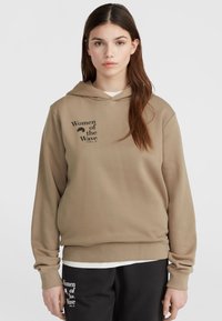 Beige mikina s predným vreckom a šnúrkou na kapucni, s potlačou čierneho textu "Women of the Wave" na hrudi. Jemná, textúrovaná látka.