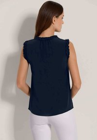 Marineblaue ärmellose Bluse mit Rüschendetails an den Schultern, glatter Textur, leicht abgerundetem Saum und gerafftem Halsausschnitt.