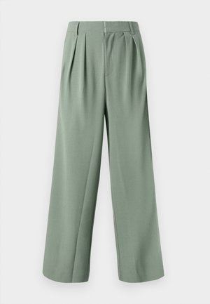Calças largas verde com pregas, feitas de um tecido suave. Apresentam um fecho com zip e dois bolsos laterais. Design simples e bem ajustado.