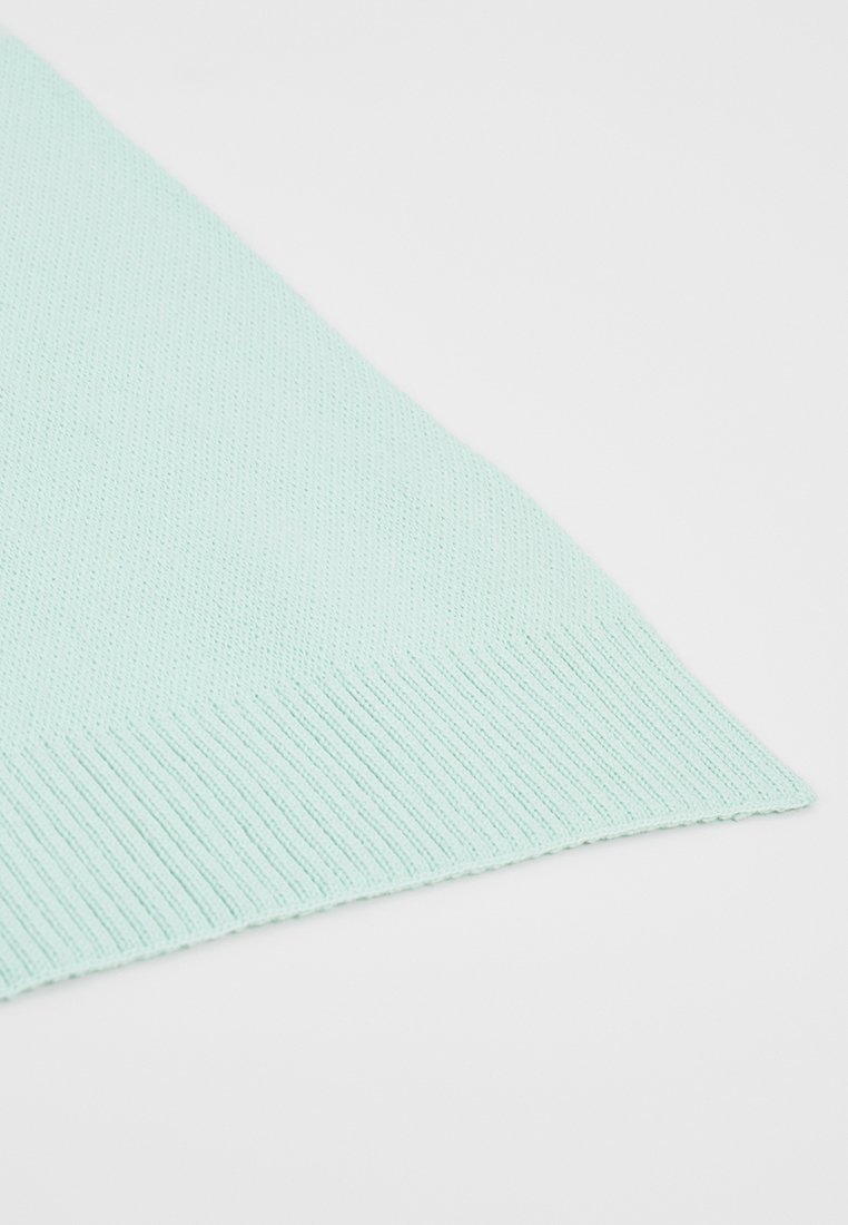 Helles minzgrünes gestricktes Gewebe mit einer gerippten Textur, schräg entlang der Kante, und zeigt eine glatte, flache Oberfläche sowie ein definiertes Stichmuster.