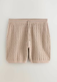 Bézs színű kötött rövidnadrág hullámos mintával, rugalmas derékkal, húzózsinórral és oldalzsebekkel, egyszínű háttéren.