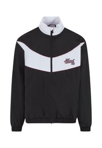 Veste coupe-vent noire avec un motif en chevron blanc et des accents rouges. Elle dispose d'un col montant et de poignets et d'un ourlet élastiques.