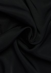 Tessuto nero con una texture liscia e leggermente lucida, che mostra un motivo intrecciato. Il materiale è leggero e versatile.