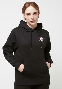 Hoodie noir en mélange de coton, avec une poche avant, un capuchon ajustable avec cordon, et un design floral rose sur la poitrine.