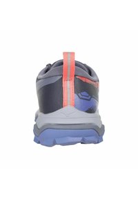 Grijze sportieve schoen met een gestructureerd oppervlak, oranje accent trekband en een blauwe zool. Heeft een verloopontwerp op het bovenwerk.