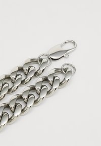 Sølvmetallkjede med en blankfinitur, som har store sammenkoblede ledd og en trygg klikklås.