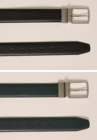 Divi ādas jostas izlīdzinātas. Viena ir melna ar sudraba sprādzi; otra ir tumši zaļa, arī ar sudraba sprādzi. Abām ir pieci caurumi.