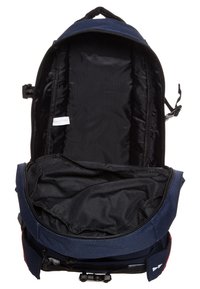 Mochila navy con un interior forrado en negro; cuenta con un cierre de cremallera, correas ajustables y un bolsillo lateral con clip.