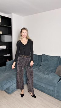 Juodas ilgomis rankovėmis uždangalas su nėriniu ir raštuotomis plataus kirpimo kelnėmis. Kelnės turi zebra juostelių dizainą. Juodos aukštakulnės bateliai.