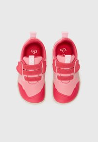 Pink athletic shoes with mesh upper, rubber soles, Velcro straps, and heart-shaped accents. Lightweight design with varying shades of pink.
