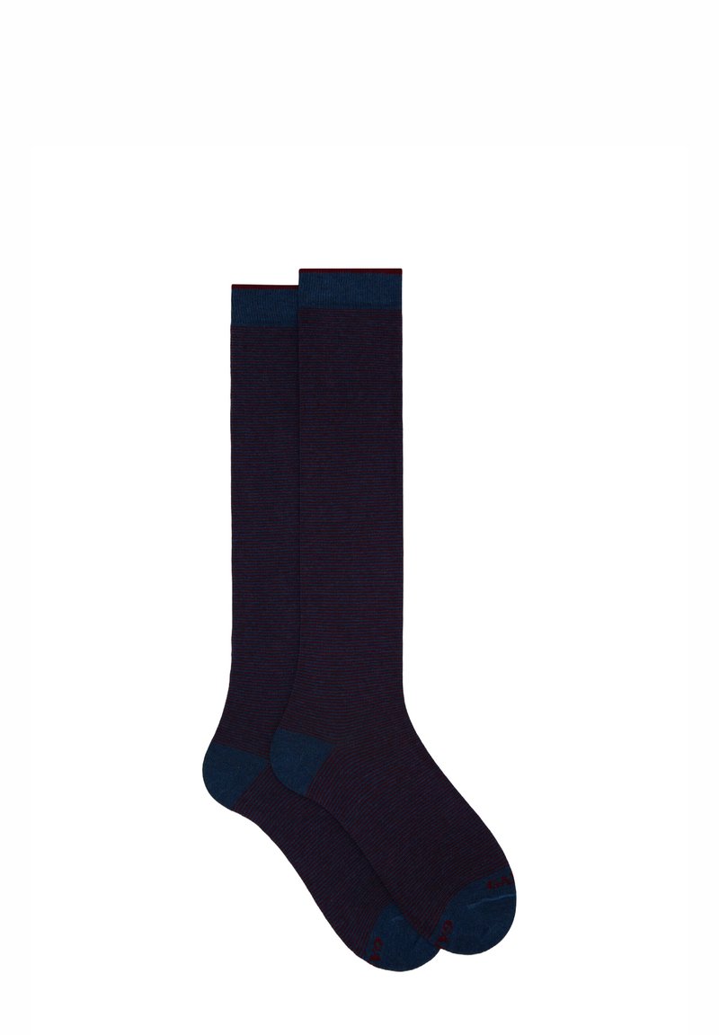 Calze al ginocchio di colore viola scuro con una texture a coste. Accenti di contrasto blu scuro sul risvolto e sulla punta. Realizzate in un materiale morbido e elastico.