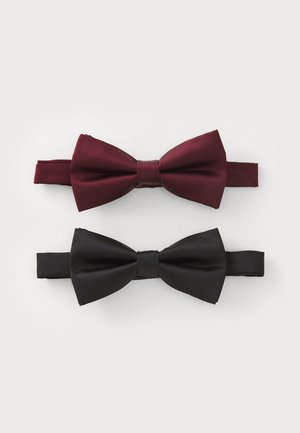 Deux nœuds papillon en satin sont présentés : un bordeaux et un noir, tous deux dotés de textures lisses et de strap élastiques pour la fermeture.