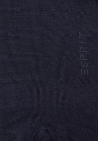 Marineblaue Stricksocken mit einer glatten Textur, die ein dezentes Logo-Muster "ESPRIT" in den Stoff eingearbeitet haben.