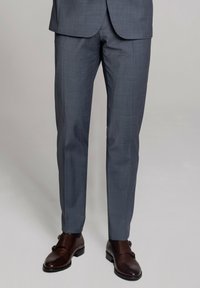 Szare spodnie garniturowe o delikatnym wzorze w kratę, g�ładkiej teksturze i dopasowanym kroju, zestawione z wypolerowanymi brązowymi skórzanymi butami.