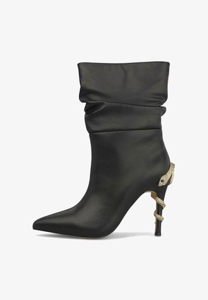 Bota negra de cuero hasta la mitad de la pantorrilla con punta puntiaguda y tacón de aguja alto envuelto con un detalle dorado en forma de serpiente.