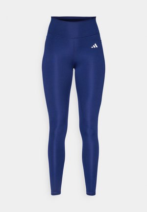 Tamnoplave tajice od rastezljivog materijala s visokim strukom. Sadrži bijeli Adidas logo na prednjoj lijevoj natkoljenici.
