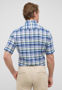 Camicia a maniche corte a quadri blu, verde e bianco. Presenta un colletto classico e una vestibilità comoda, realizzata in tessuto traspirante.