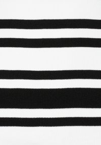 Svart och vit randig tyg; alternerande horisontella ränder av varierande bredd; slät textur med ett stickat mönster.