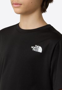 Μαύρο κοντομάνικο μπλουζάκι κατασκευασμένο από απαλό ύφασμα, με λευκό λογότυπο στο πάνω αριστερό μέρος του στήθους, στρογγυλή λαιμόκοψη και άνετη εφαρμογή.