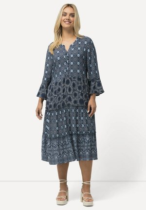 Blau gemustertes Kleid mit V-Ausschnitt, dreiviertellangen Glockenärmeln, gestuftem Design und ausgestelltem Saum. Das Material wirkt leicht und fließend.