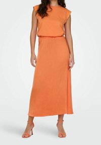 Oranžové maxi šaty s krátkými volánovými rukávy, elastickým pasem a bočním rozparkem. Hladká tkanina s lehkým střihem, doplněné oranžovými podpatky.