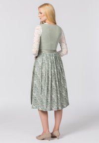 Langes grünes Kleid mit einem strukturierten Oberteil, einem gefältelten Blumensrock, einer satinfarbenen Taillenband und langen Spitzenärmeln.