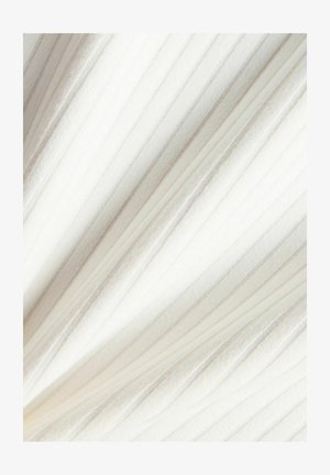 Hvidt stof med lodret ribbet tekstur og bløde folder, der skaber diagonale skygger over overfladen.
