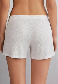 Witte ribgebreide katoenen shorts met een zachte textuur, voorzien van een eenvoudige tailleband en een rechte snit, afgewerkt aan de benen.